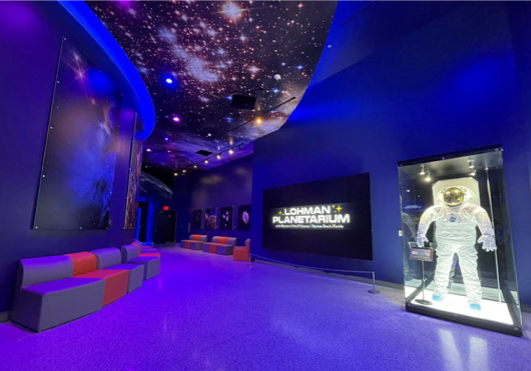 Asset 69@4x PIcture inside museum and sign for planetarium. Also pictured spacesuit in exhibit.